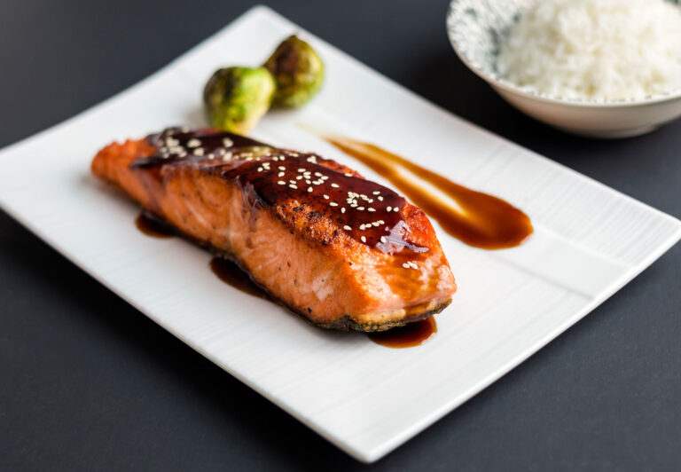 Teriyaki salmon on black background.