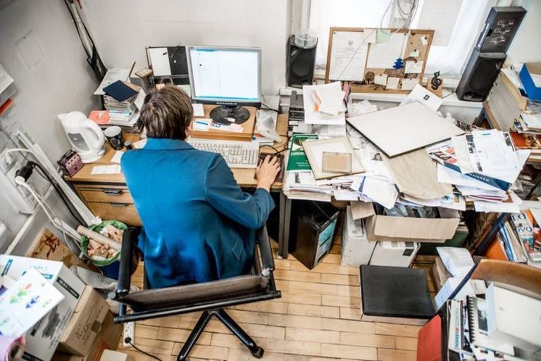 worker at cluttered desk photo-6832-623753dadab5b758c39c88d903ee9ab8@2x