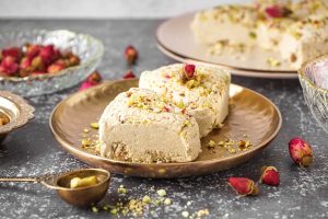 Plates with pieces of tasty Tahini halva on grunge background