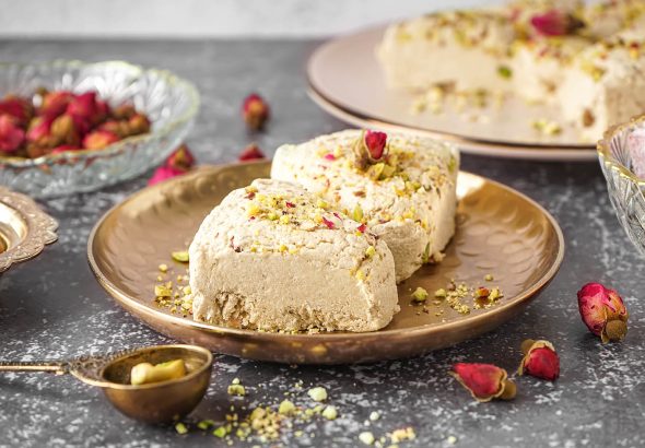 Plates with pieces of tasty Tahini halva on grunge background