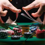 Girl dealer or croupier shuffles poker cards in a casino on the background of a table, chips,. Concept of poker game, game business